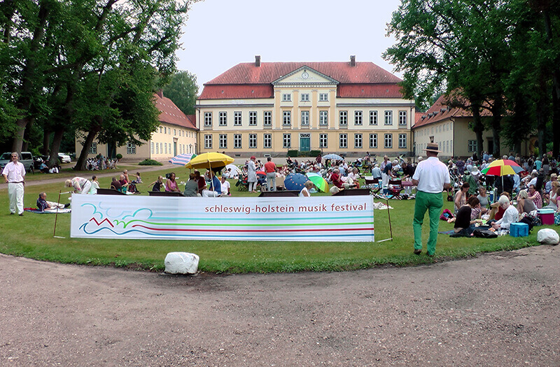 Menschen auf dem Vorplatz des Gut Emkendorf beim Musikfestival