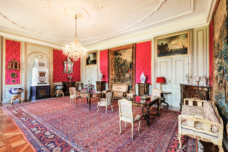 Salon mit roten, leuchtenden Wänden und stilvollen Möbeln